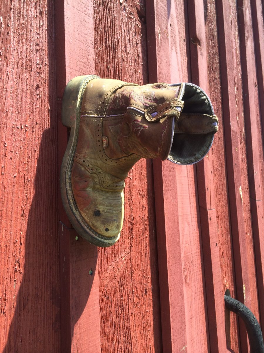 there is a cowboy boot on a red barn wall