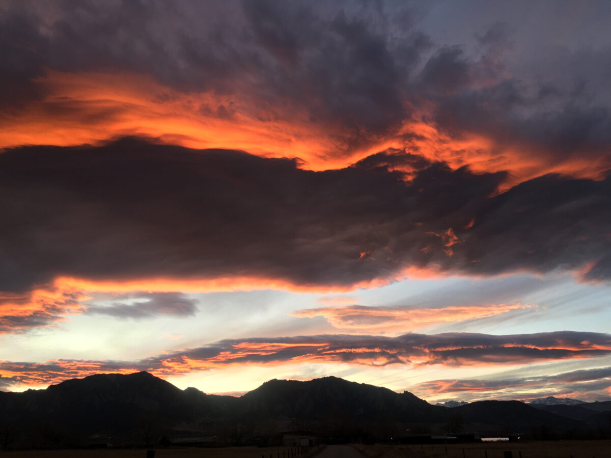 photo of sunset with red, pinks, vibrant fire colors in clouds