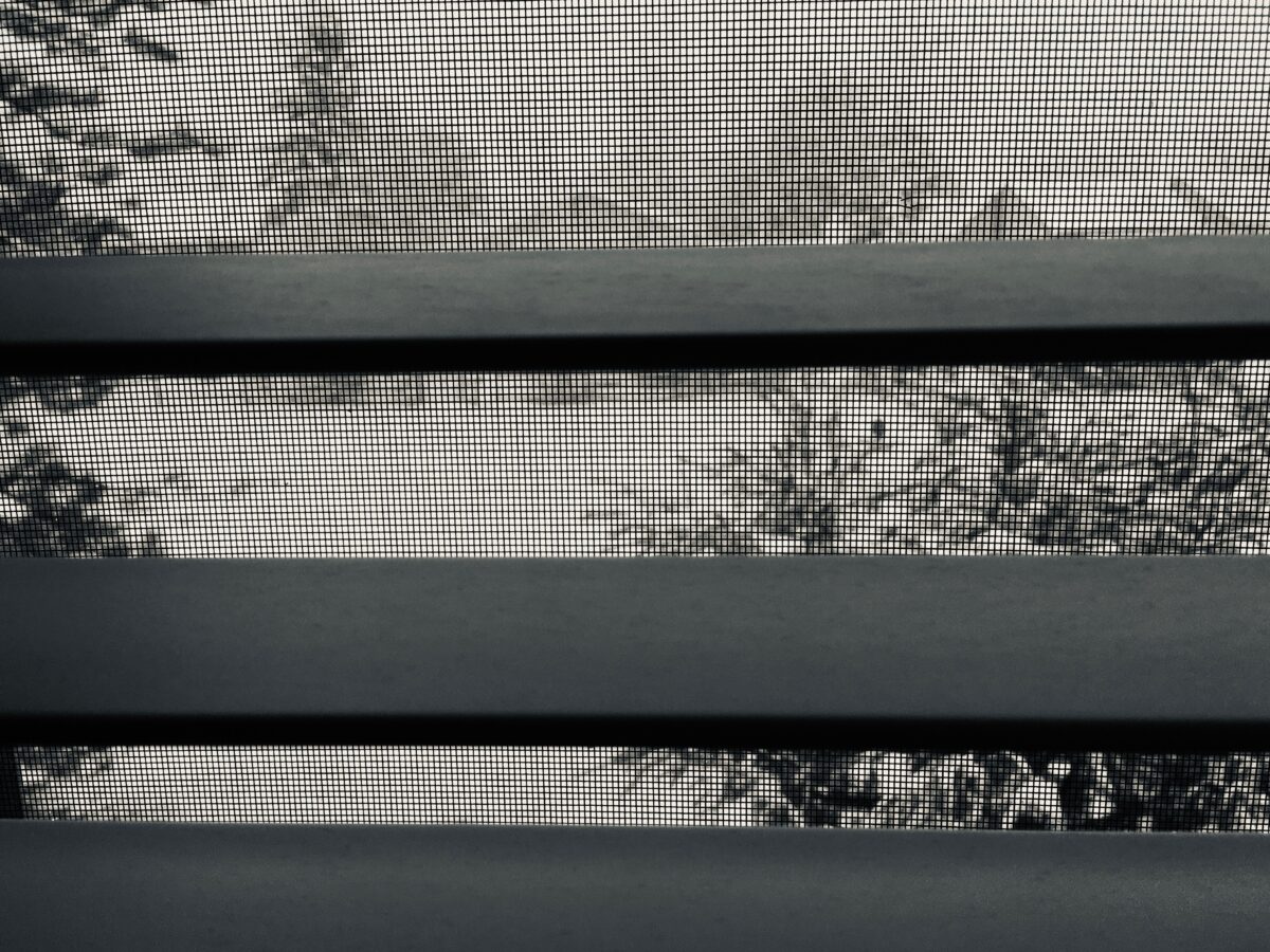 slats of blinds looking out to a snow covered yard